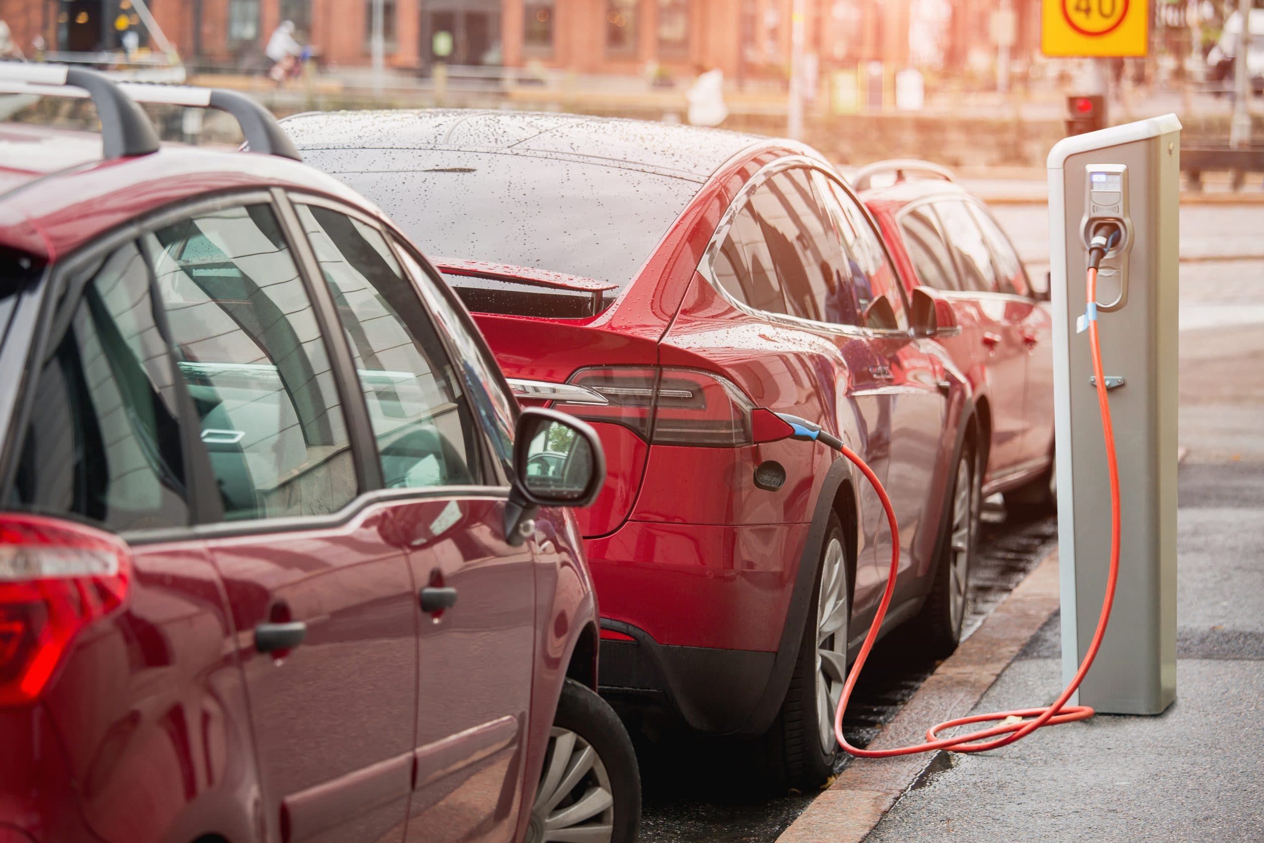 red electric vehicle charging whilst parked on the street