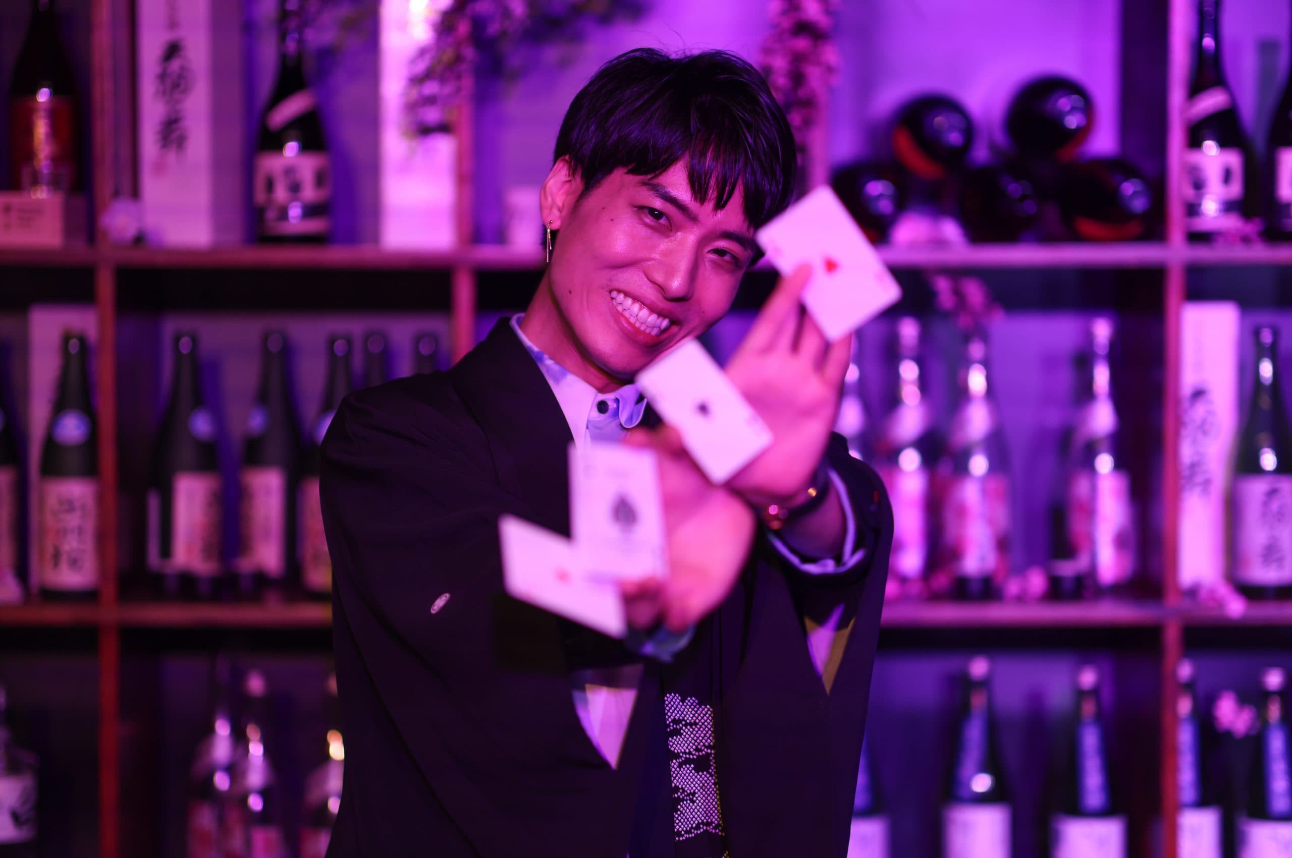 Shirayuri at Maho Magic Bar. Magic. Man with cards. Magic trick. Alcoholic bar in the background.