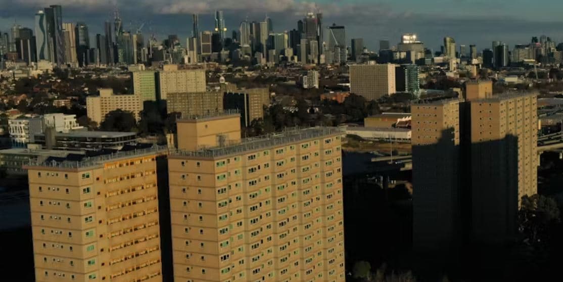 Public housing towers in Melbourne, with city skyline in background.