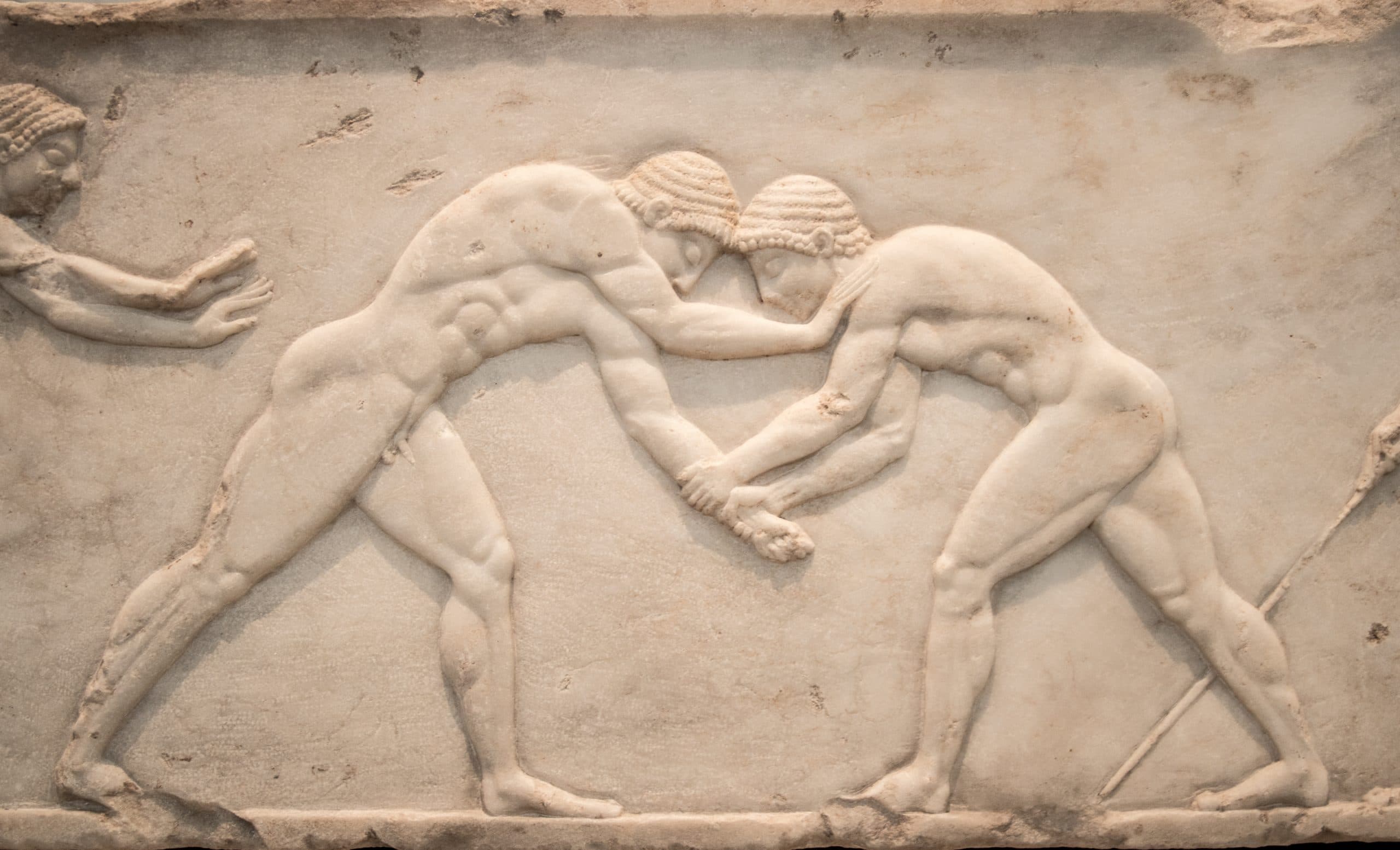 Marble low relief carving of ancient Greek wrestlers in action. on From a grave stele in Kerameikos Athens, Greece.