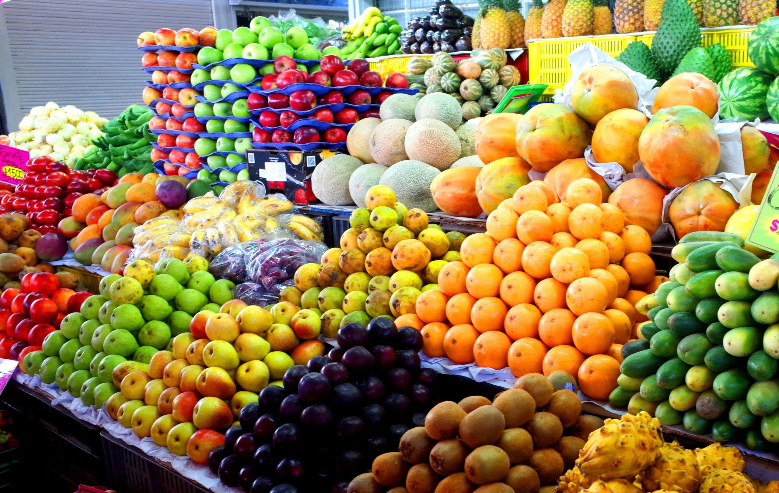 Vegetables and fruit piled on display at a market. Credit James Wagstaff / Shutterstock.com
