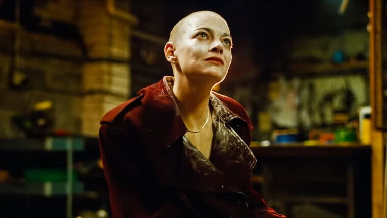image of emma stone in the movie bugonia, her head is shaved and she's in a warehouse
